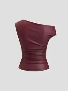 Back view of a burgundy faux leather asymmetrical top with one-shoulder construction, fitted body, and softly gathered waist.