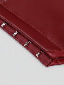 Close-up of a red leather clutch or envelope-style handbag corner with silver-tone metal hardware along the edge, shown on a light gray background.