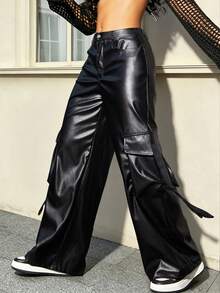 Black wide-leg cargo pants with a glossy faux-leather finish, featuring side tie details and large flap pockets, modeled with white sneakers.